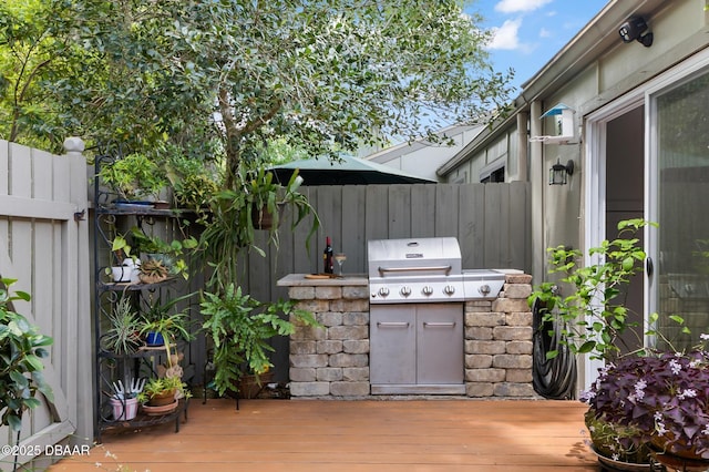 view of patio / terrace featuring a deck, fence, and a grill