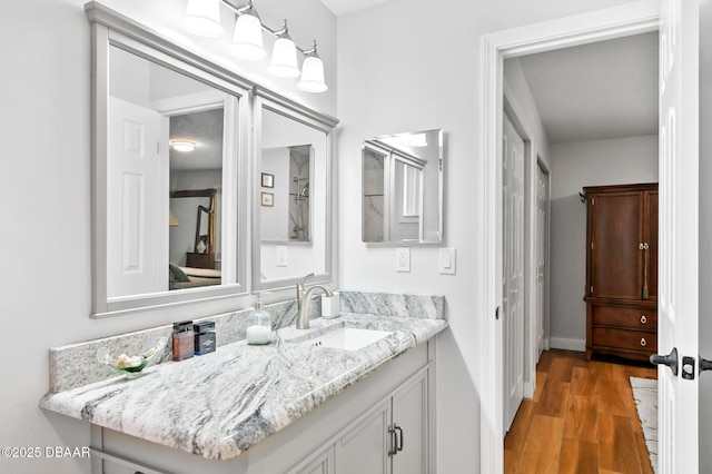 bathroom with vanity, baseboards, and wood finished floors