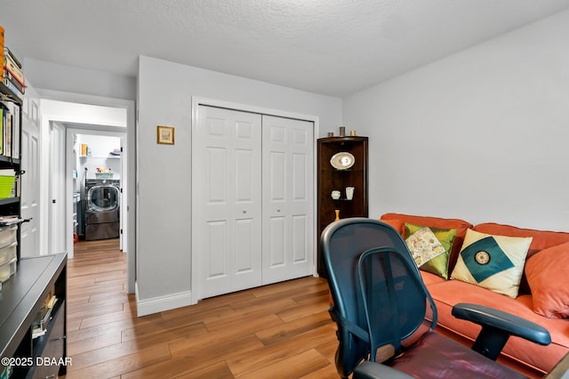 office featuring washer / dryer, baseboards, and light wood finished floors
