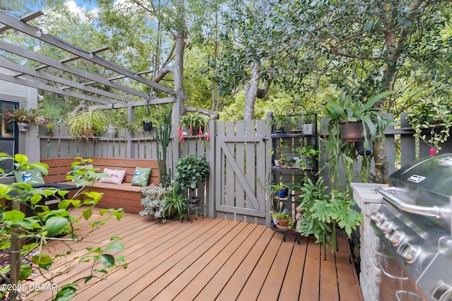 wooden terrace with fence, a gate, a pergola, and a grill