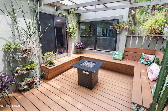 wooden terrace featuring a pergola and a fire pit