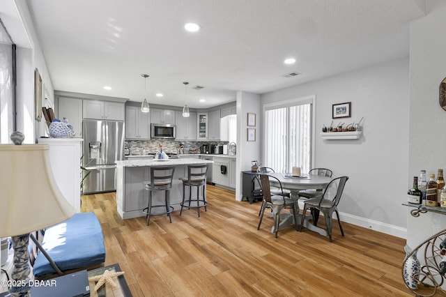 dining room featuring visible vents, recessed lighting, light wood-style floors, and baseboards