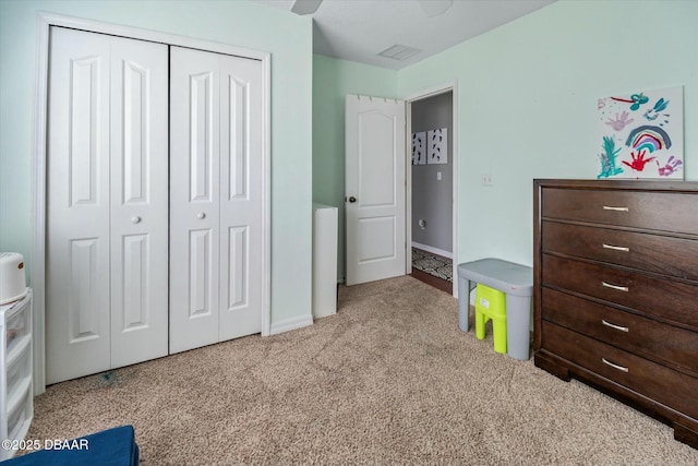 carpeted bedroom featuring ceiling fan and a closet