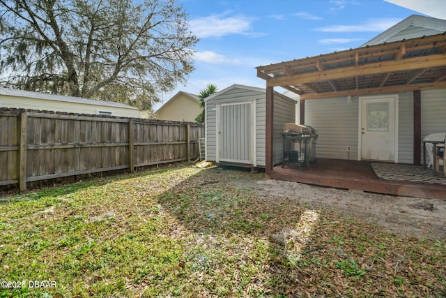 view of yard featuring a deck and a storage unit