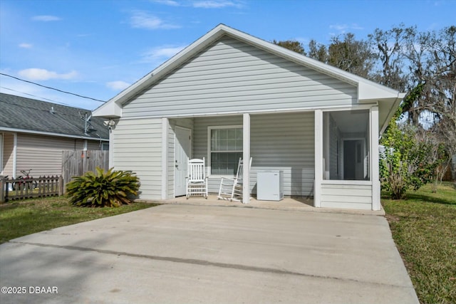 rear view of property featuring a yard and a porch