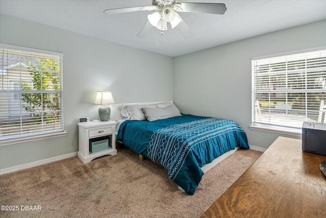 bedroom with ceiling fan, multiple windows, and carpet flooring