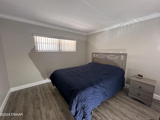 bedroom with crown molding, dark hardwood / wood-style flooring, and a textured ceiling