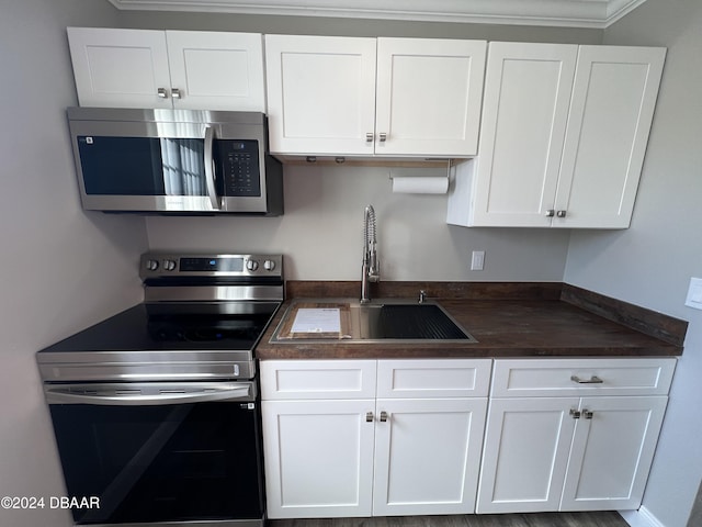 kitchen featuring crown molding, sink, white cabinets, and appliances with stainless steel finishes