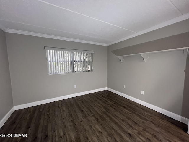 spare room with dark wood-type flooring and crown molding