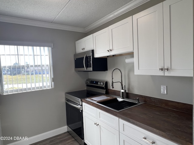 kitchen with dark wood-type flooring, white cabinets, crown molding, sink, and appliances with stainless steel finishes