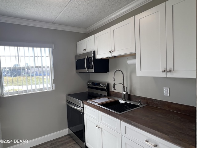 1510 Ocean Shore Blvd Unit 3120, Ormond Beach, FL 32176 - kitchen with appliances with stainless steel finishes, a sink, a textured ceiling, ornamental molding, and white cabinets