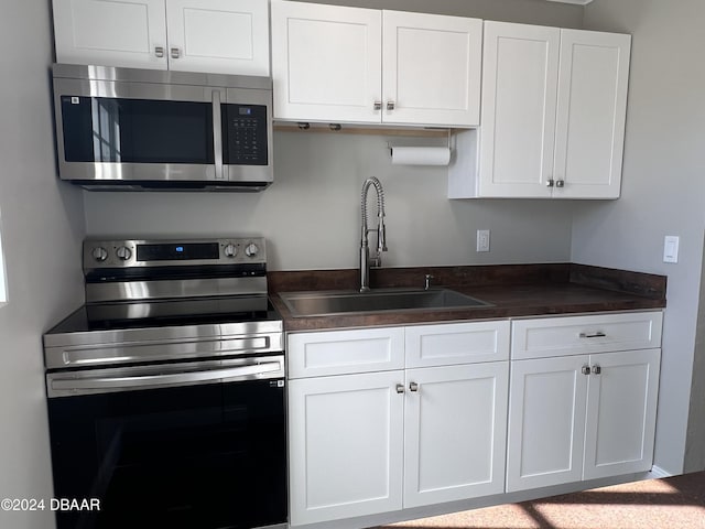 kitchen with sink, white cabinets, and stainless steel appliances