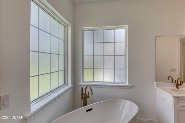 bathroom featuring a tub to relax in and vanity