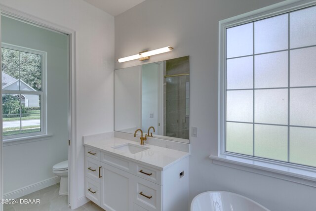 full bathroom with toilet, plenty of natural light, vanity, and tile patterned floors