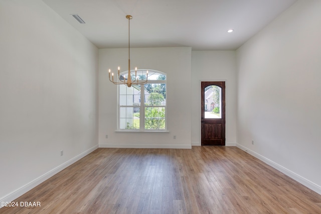 entrance foyer with light hardwood / wood-style flooring and an inviting chandelier