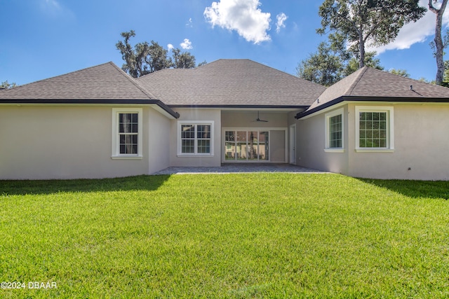 back of property with ceiling fan, a lawn, and a patio