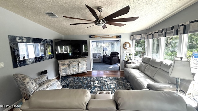 living area featuring lofted ceiling, visible vents, ceiling fan, a textured ceiling, and wood finished floors