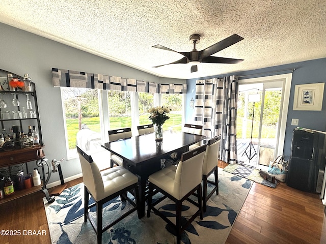 dining room featuring a ceiling fan, a textured ceiling, baseboards, and wood finished floors