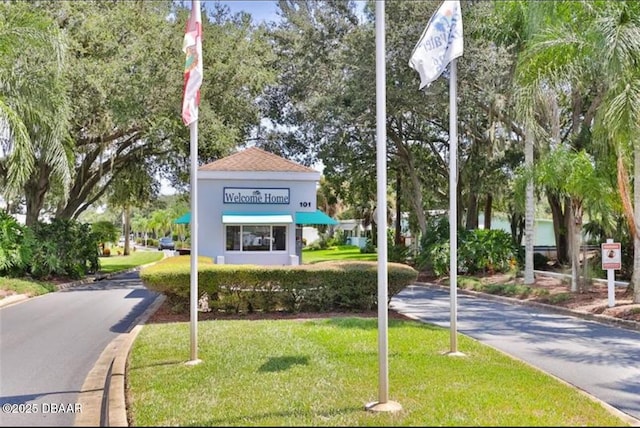 view of community featuring aphalt driveway and a yard