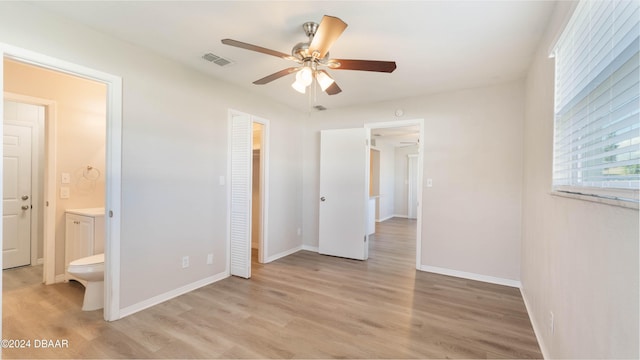 unfurnished bedroom with ceiling fan, a closet, light hardwood / wood-style flooring, and ensuite bath