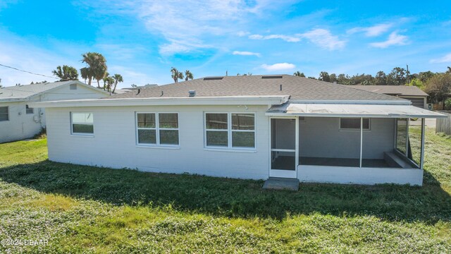 rear view of property with a sunroom and a yard