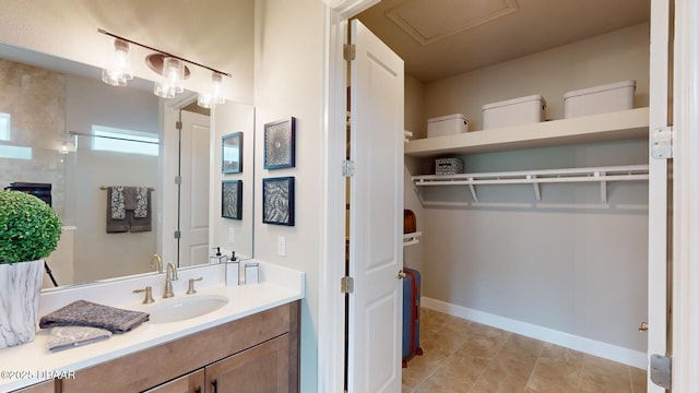 191 Aspen Way, Palm Coast, FL 32137 - bathroom featuring vanity, tile patterned floors, baseboards, and a walk in closet