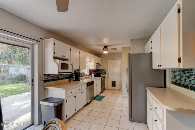 kitchen featuring white cabinets, appliances with stainless steel finishes, and tasteful backsplash