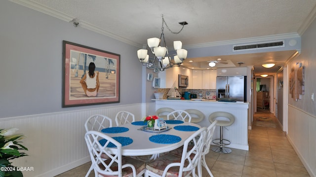 tiled dining space with wooden walls, a textured ceiling, and crown molding