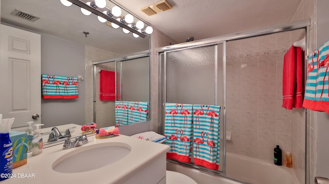 full bathroom featuring bath / shower combo with glass door, vanity, and toilet