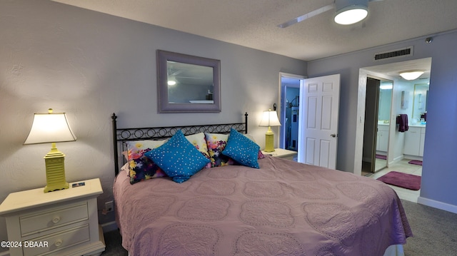 carpeted bedroom featuring a textured ceiling, ceiling fan, and ensuite bathroom