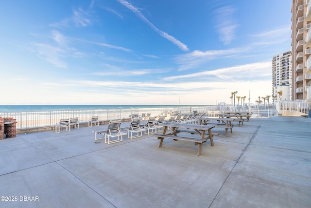 view of patio featuring a beach view and a water view