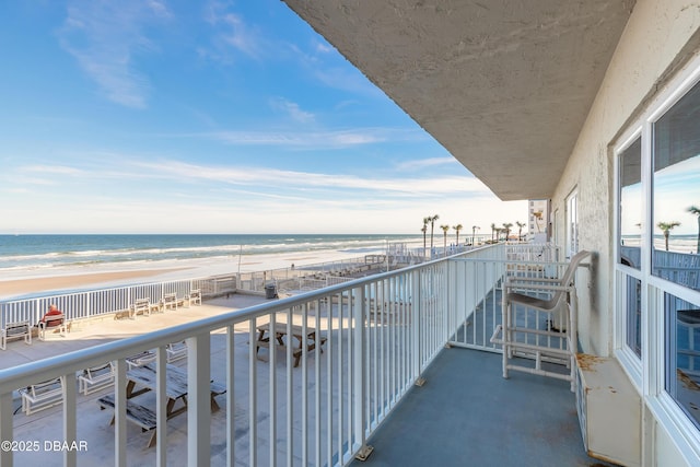 balcony with a water view and a beach view