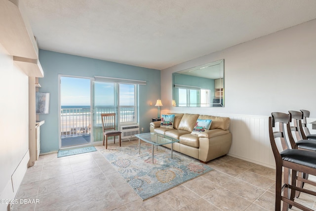 tiled living room featuring a water view and a textured ceiling