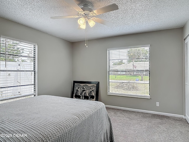 7 Heather Ln, Ormond Beach, FL 32174 - carpeted bedroom featuring baseboards, multiple windows, a textured ceiling, and a ceiling fan