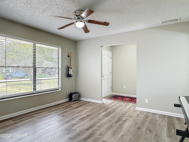 7 Heather Ln, Ormond Beach, FL 32174 - unfurnished room with light wood-style floors, ceiling fan, a textured ceiling, and baseboards