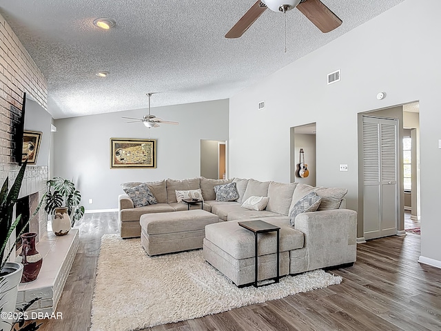 7 Heather Ln, Ormond Beach, FL 32174 - living room with a ceiling fan, lofted ceiling, a brick fireplace, a textured ceiling, and wood finished floors
