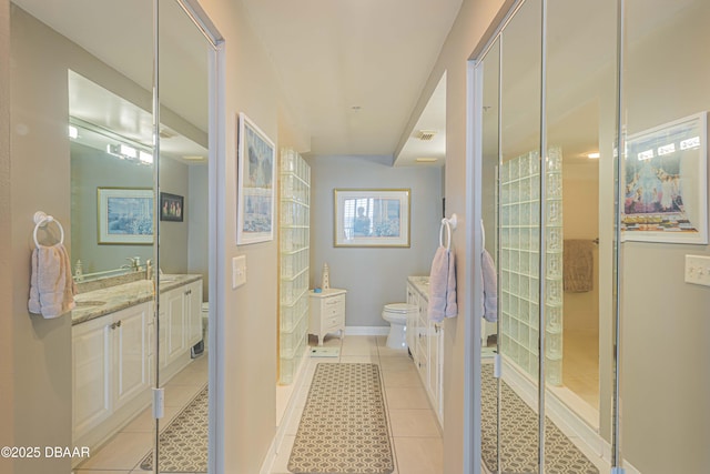 bathroom with a shower, toilet, vanity, and tile patterned flooring