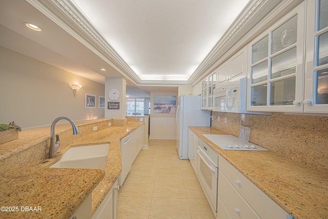 kitchen featuring white appliances, white cabinetry, decorative backsplash, sink, and light stone counters