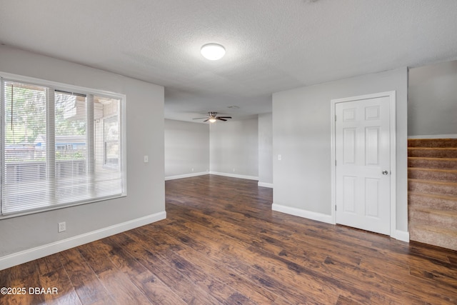 3656 Jackson St Unit 11, Port Orange, FL 32129 - spare room featuring dark wood-type flooring, stairs, a ceiling fan, baseboards, and a textured ceiling