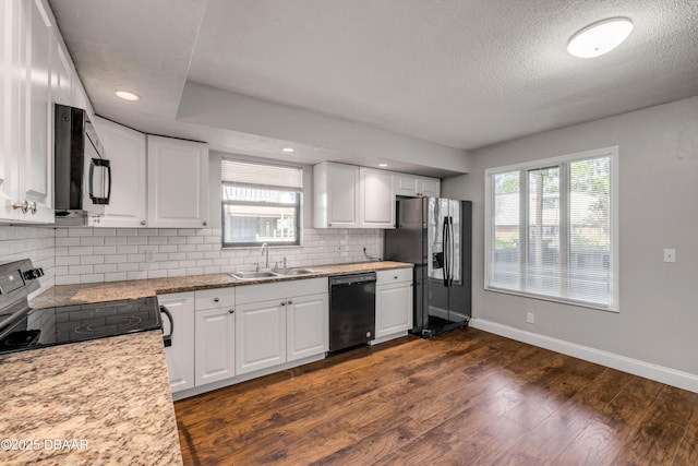 3656 Jackson St Unit 11, Port Orange, FL 32129 - kitchen featuring white cabinets, a sink, baseboards, black appliances, and backsplash