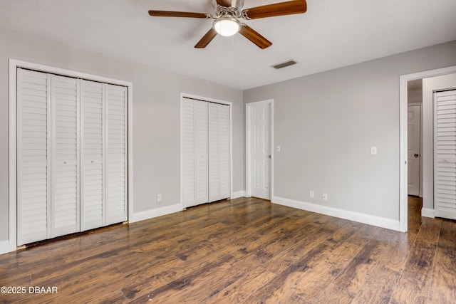 3656 Jackson St Unit 11, Port Orange, FL 32129 - unfurnished bedroom featuring baseboards, visible vents, wood finished floors, and two closets