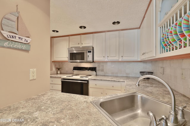 3051 S Atlantic Ave Unit 1806, Daytona Beach Shores, FL 32118 - kitchen featuring electric stove, stainless steel microwave, a sink, backsplash, and a textured ceiling