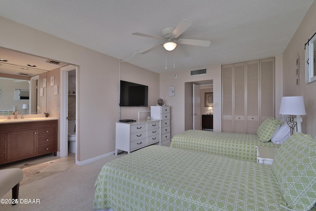 3051 S Atlantic Ave Unit 1806, Daytona Beach Shores, FL 32118 - bedroom with light colored carpet, a closet, ensuite bathroom, baseboards, and a sink