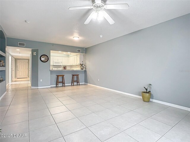 5300 S Atlantic Ave Unit 9-403, New Smyrna Beach, FL 32169 - unfurnished living room with light tile patterned floors, visible vents, a textured ceiling, and ceiling fan