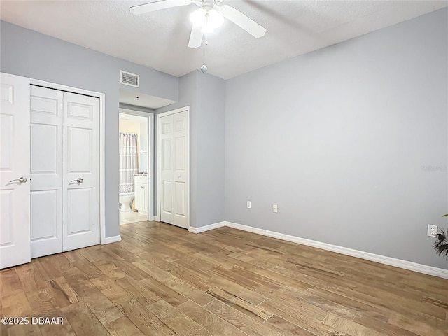 5300 S Atlantic Ave Unit 9-403, New Smyrna Beach, FL 32169 - unfurnished bedroom featuring light wood-style floors, ceiling fan, ensuite bath, visible vents, and baseboards