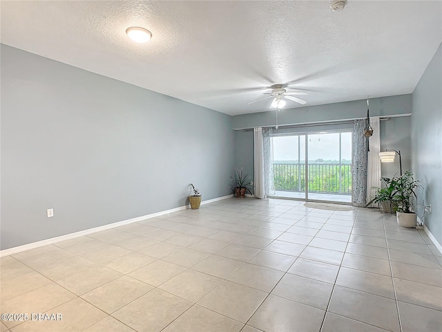 5300 S Atlantic Ave Unit 9-403, New Smyrna Beach, FL 32169 - spare room featuring ceiling fan, light tile patterned flooring, baseboards, and a textured ceiling