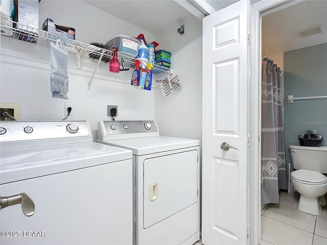 5300 S Atlantic Ave Unit 9-403, New Smyrna Beach, FL 32169 - clothes washing area with light tile patterned floors, visible vents, washer and clothes dryer, and laundry area