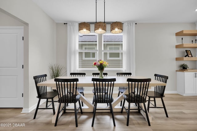 dining area with a notable chandelier and light hardwood / wood-style flooring