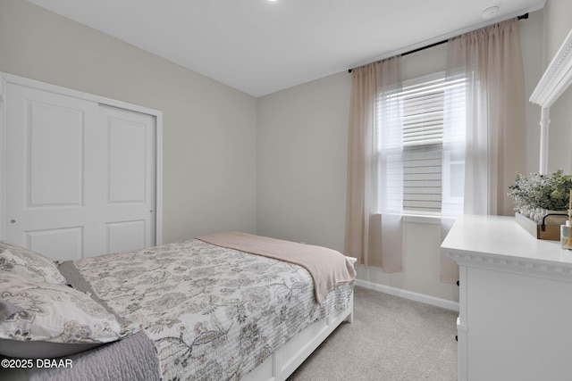 bedroom with light carpet and a closet