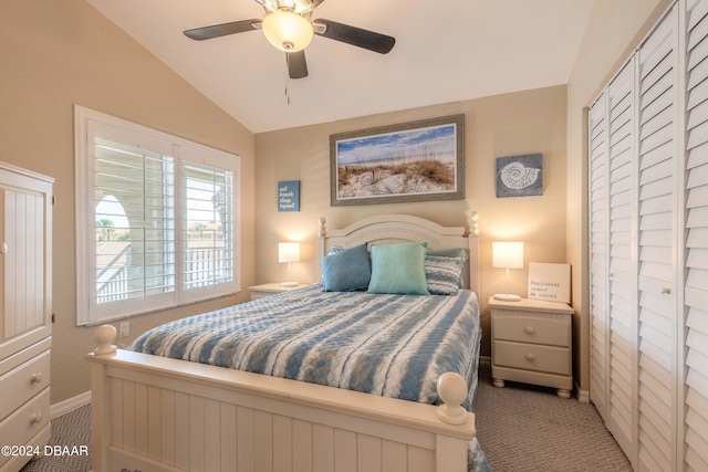 carpeted bedroom featuring ceiling fan, vaulted ceiling, and a closet